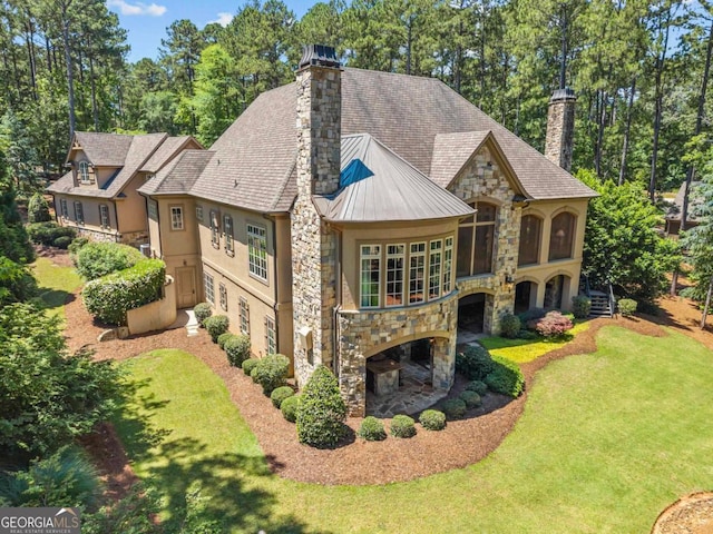 1031 Sugar Run, Greensboro, GA 30642 - view of front of home featuring stone siding, a chimney, a front yard, stucco siding, and a standing seam roof