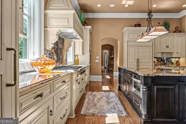 1031 Sugar Run, Greensboro, GA 30642 - kitchen with stainless steel gas stovetop, arched walkways, tasteful backsplash, light stone counters, and dark wood finished floors