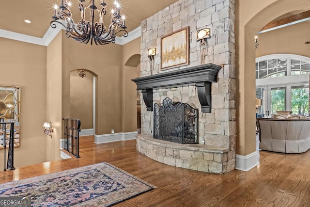 1031 Sugar Run, Greensboro, GA 30642 - living area with arched walkways, crown molding, a high ceiling, wood finished floors, and a fireplace
