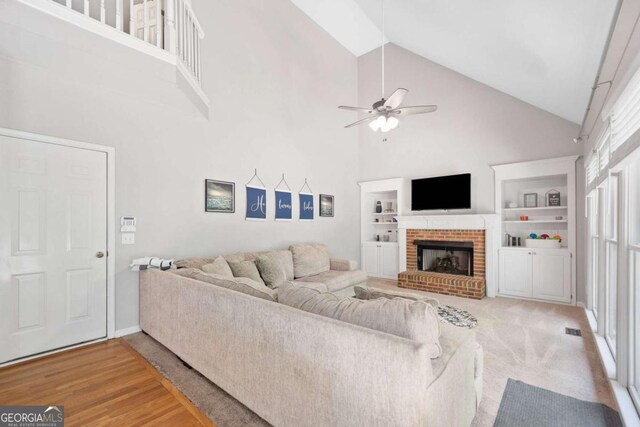 117 Willow View Ln, Canton, GA 30114 - living area with high vaulted ceiling, a ceiling fan, a brick fireplace, built in features, and light wood finished floors