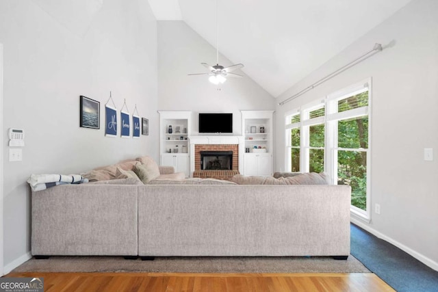 117 Willow View Ln, Canton, GA 30114 - living room featuring a ceiling fan, a fireplace, high vaulted ceiling, built in features, and wood finished floors