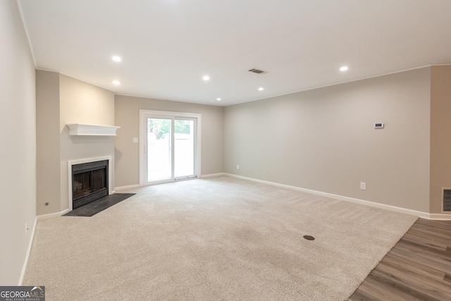 1017 Ridgefield Dr, Peachtree City, GA 30269 - unfurnished living room featuring a fireplace with flush hearth, baseboards, recessed lighting, and wood finished floors