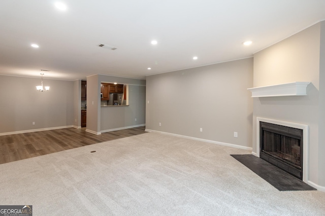 1017 Ridgefield Dr, Peachtree City, GA 30269 - unfurnished living room featuring a fireplace with flush hearth, light carpet, recessed lighting, a chandelier, and baseboards