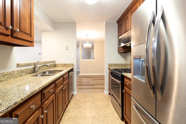 1017 Ridgefield Dr, Peachtree City, GA 30269 - kitchen featuring stainless steel appliances, a sink, light stone countertops, baseboards, and a chandelier