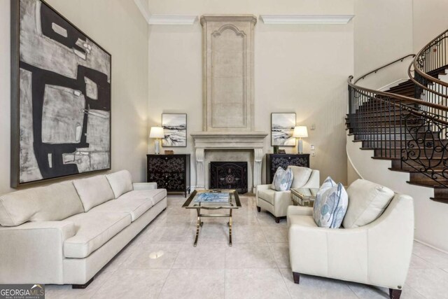 3280 Stillhouse Ln SE Unit 212, Atlanta, GA 30339 - living room featuring a towering ceiling, stairs, ornamental molding, light tile patterned floors, and a premium fireplace