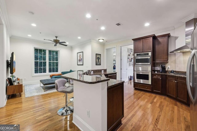 3280 Stillhouse Ln SE Unit 212, Atlanta, GA 30339 - kitchen featuring ornamental molding, a kitchen breakfast bar, recessed lighting, light wood finished floors, and dark stone countertops