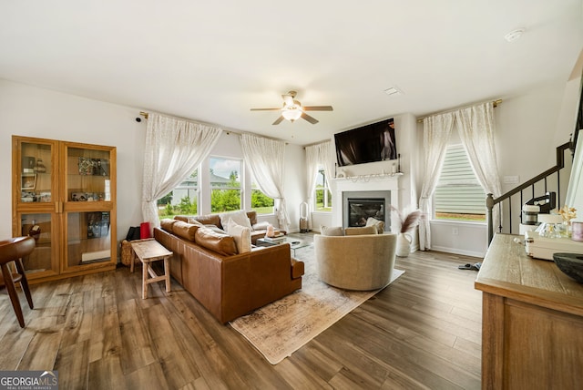 4720 Dufour Dr, Lilburn, GA 30047 - living room with stairway, a ceiling fan, wood finished floors, and a glass covered fireplace