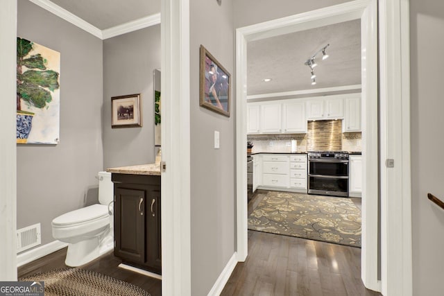 4320 Oklahoma Way NW, Kennesaw, GA 30152 - bathroom with vanity, ornamental molding, wood finished floors, toilet, and tasteful backsplash