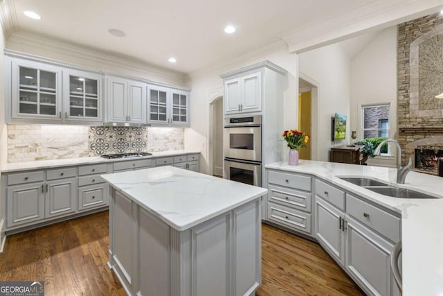 8970 Moor Park Run, Duluth, GA 30097 - kitchen featuring stainless steel double oven, gray cabinets, gas stovetop, tasteful backsplash, and a kitchen island