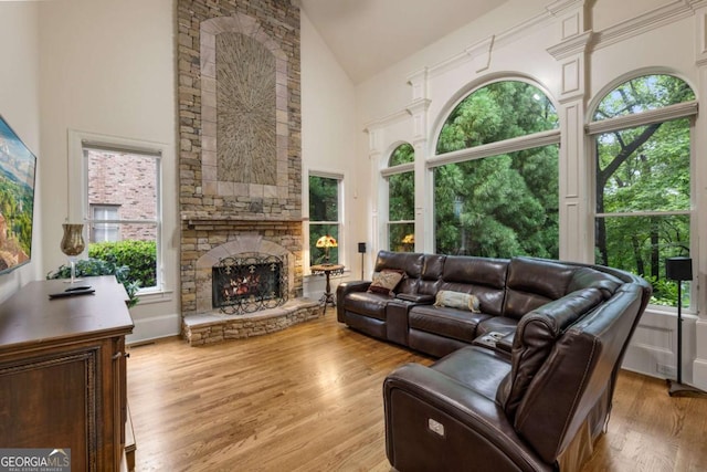8970 Moor Park Run, Duluth, GA 30097 - living room featuring high vaulted ceiling, a stone fireplace, wood finished floors, and plenty of natural light