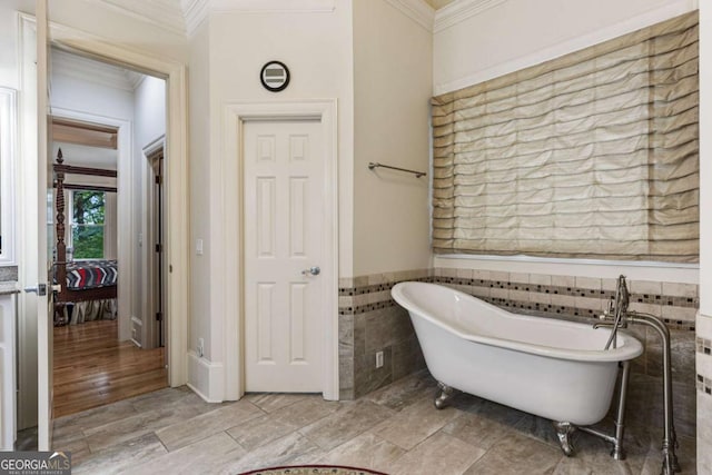 8970 Moor Park Run, Duluth, GA 30097 - full bathroom with ornamental molding, tile walls, a freestanding bath, and a wainscoted wall