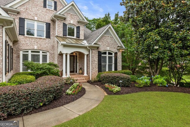 8970 Moor Park Run, Duluth, GA 30097 - view of front of house with brick siding, a front yard, and a standing seam roof