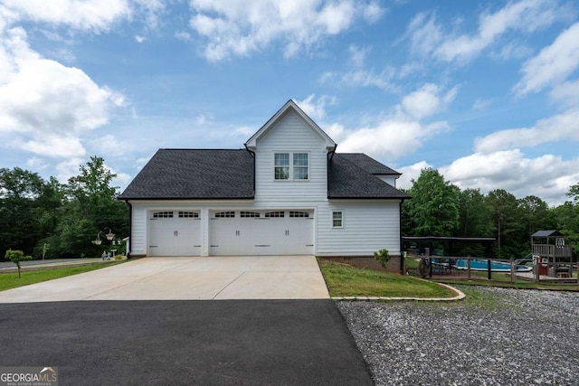 1270 Mccannon Morris Rd, Hull, GA 30646 - view of property exterior with driveway, roof with shingles, a playground, and an attached garage