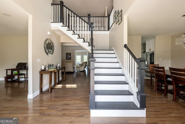 1270 Mccannon Morris Rd, Hull, GA 30646 - stairway with wood finished floors, a chandelier, a towering ceiling, and baseboards