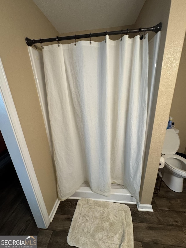 353 Mosley Rd, Vidalia, GA 30474 - bathroom with toilet, baseboards, wood finished floors, and a shower stall