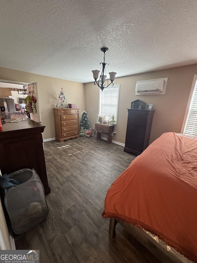 353 Mosley Rd, Vidalia, GA 30474 - bedroom with a wall mounted AC, dark wood-type flooring, a chandelier, a textured ceiling, and baseboards
