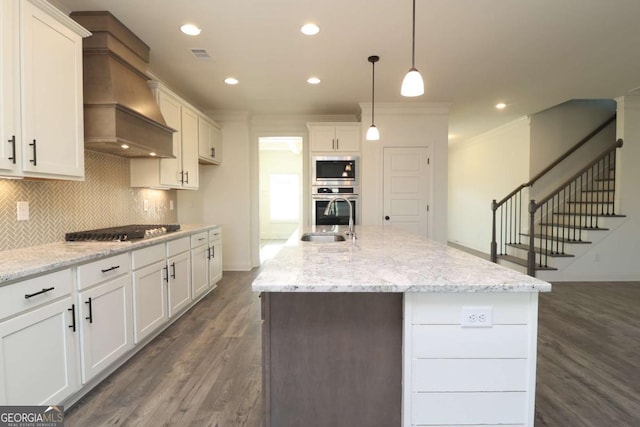 599 Calgary Downs Dr, Winder, GA 30680 - kitchen featuring custom exhaust hood, stainless steel appliances, dark wood-type flooring, white cabinets, and ornamental molding