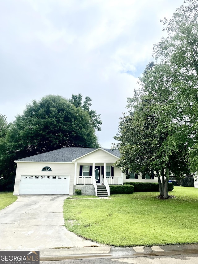 305 Lancelot Ln, Dublin, GA 31021 - view of front of property with concrete driveway, a front lawn, covered porch, and an attached garage