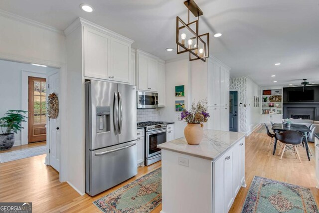 4402 Sugar Maple Pl, Gainesville, GA 30506 - kitchen with stainless steel appliances, a chandelier, white cabinetry, light wood-style floors, and a kitchen island