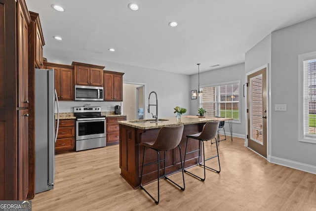 419 Highland Pointe Dr, Alto, GA 30510 - kitchen featuring appliances with stainless steel finishes, light wood-style flooring, a breakfast bar, light stone counters, and recessed lighting
