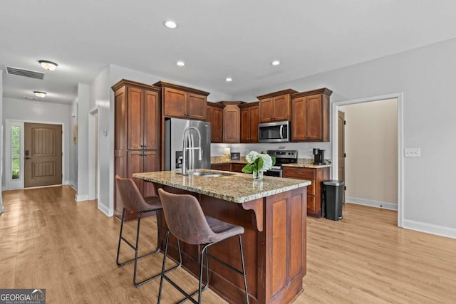 419 Highland Pointe Dr, Alto, GA 30510 - kitchen with stainless steel appliances, light wood-style floors, a breakfast bar area, light stone countertops, and recessed lighting