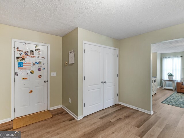 300 Furrow Creek Ct, Jackson, GA 30233 - foyer entrance with light wood-style floors, baseboards, and a textured ceiling