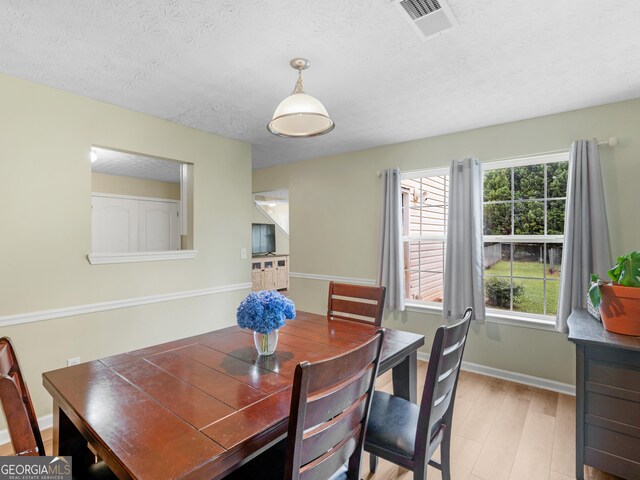300 Furrow Creek Ct, Jackson, GA 30233 - dining space featuring light wood-type flooring, a textured ceiling, and baseboards