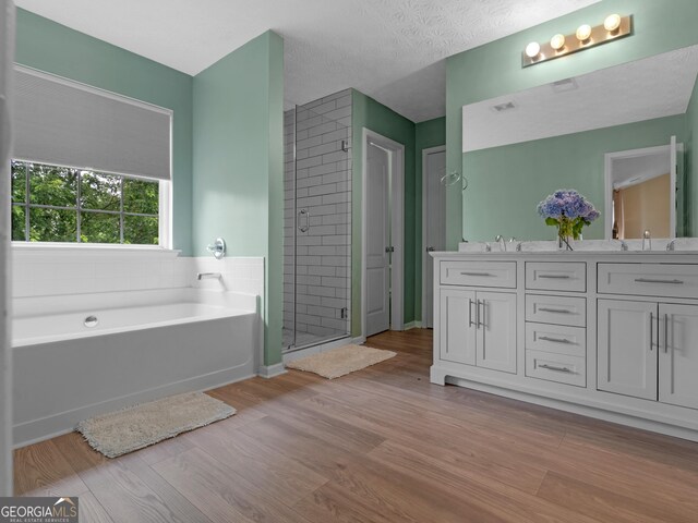 300 Furrow Creek Ct, Jackson, GA 30233 - full bathroom with a garden tub, a stall shower, double vanity, and wood finished floors
