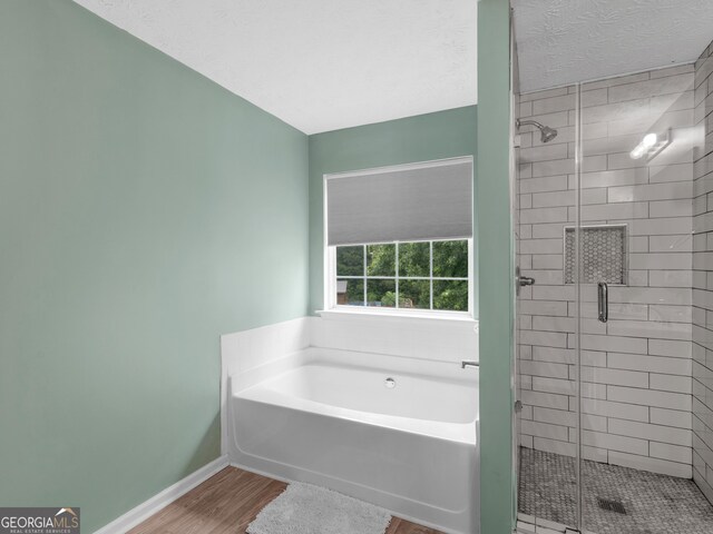300 Furrow Creek Ct, Jackson, GA 30233 - bathroom with a bath, wood finished floors, a stall shower, and baseboards