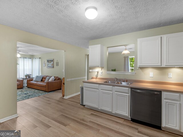 300 Furrow Creek Ct, Jackson, GA 30233 - kitchen with stainless steel dishwasher, a sink, light wood finished floors, white cabinets, and light countertops