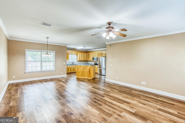 103 Mossy Creek Way, Ochlocknee, GA 31773 - unfurnished living room featuring wood finished floors, a ceiling fan, baseboards, crown molding, and a chandelier