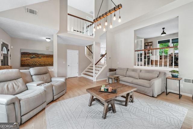 1005 Wellers Ct, Roswell, GA 30076 - living room with wood finished floors, stairway, baseboards, and a towering ceiling