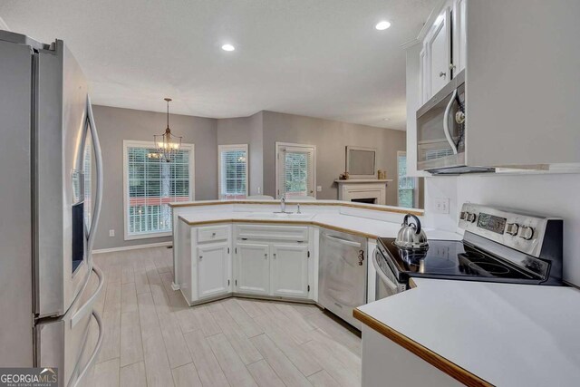 2018 Township Dr, Woodstock, GA 30189 - kitchen featuring stainless steel appliances, a chandelier, white cabinets, recessed lighting, and light countertops