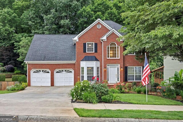 2018 Township Dr, Woodstock, GA 30189 - colonial home featuring brick siding, concrete driveway, an attached garage, and roof with shingles