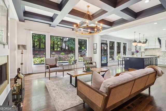 4085 Hillcrest View Ct, Suwanee, GA 30024 - living area featuring a chandelier, beam ceiling, dark wood finished floors, coffered ceiling, and a premium fireplace