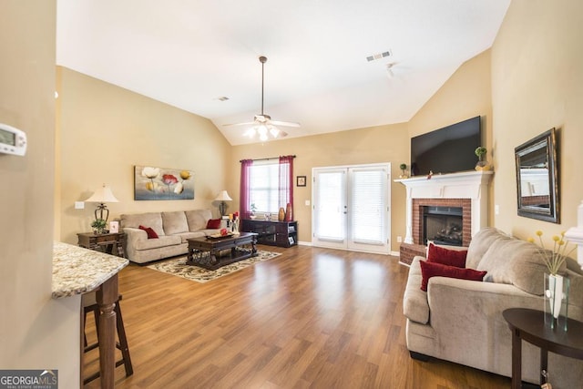 201 Loudon Hill Dr, Warner Robins, GA 31088 - living area featuring vaulted ceiling, ceiling fan, wood finished floors, a fireplace, and baseboards