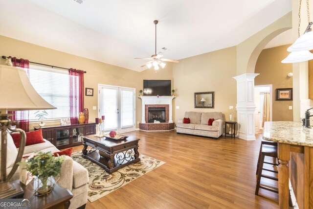 201 Loudon Hill Dr, Warner Robins, GA 31088 - living room with a brick fireplace, arched walkways, ceiling fan, high vaulted ceiling, and wood finished floors