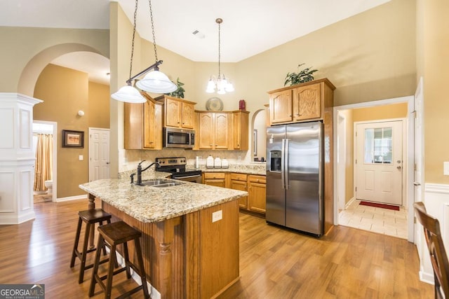 201 Loudon Hill Dr, Warner Robins, GA 31088 - kitchen with appliances with stainless steel finishes, arched walkways, a high ceiling, a sink, and a peninsula