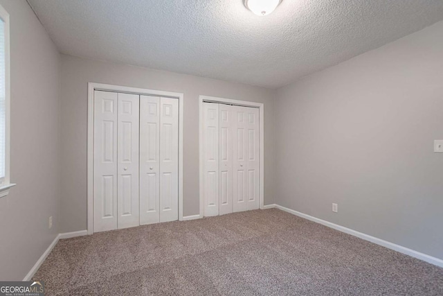 220 Harwell Rd NW, Atlanta, GA 30331 - unfurnished bedroom with multiple closets, carpet, a textured ceiling, and baseboards