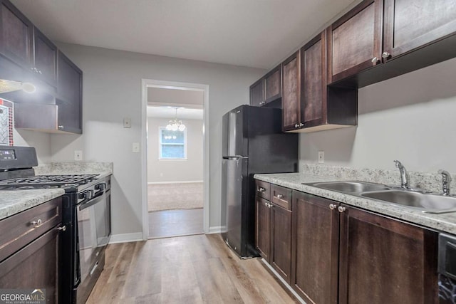 220 Harwell Rd NW, Atlanta, GA 30331 - kitchen with black range with gas stovetop, a sink, freestanding refrigerator, light wood-style floors, and dark brown cabinets