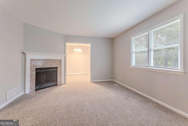 220 Harwell Rd NW, Atlanta, GA 30331 - unfurnished living room with carpet floors, baseboards, a tile fireplace, and a textured ceiling