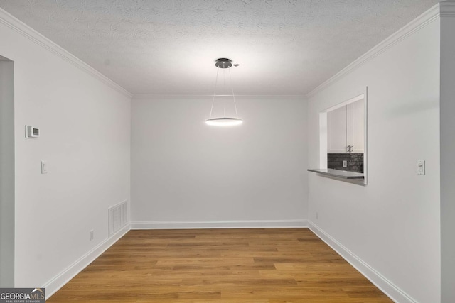 1603 Cumberland Ct, Smyrna, GA 30080 - unfurnished dining area featuring light wood finished floors, ornamental molding, baseboards, and a textured ceiling