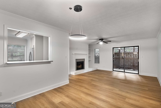 1603 Cumberland Ct, Smyrna, GA 30080 - unfurnished living room featuring built in shelves, baseboards, ceiling fan, a textured ceiling, and crown molding