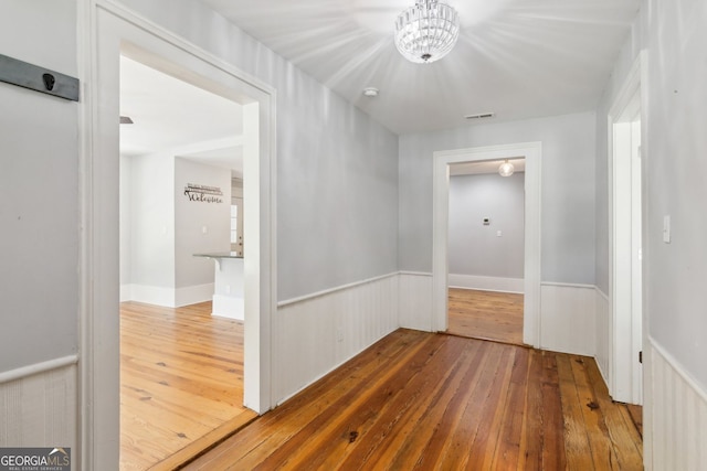1382 6th Ave, Auburn, GA 30011 - hall with hardwood / wood-style flooring, a chandelier, and a wainscoted wall