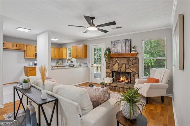 835 Navajo, Covington, GA 30016 - living room featuring light wood finished floors, crown molding, a fireplace, and ceiling fan