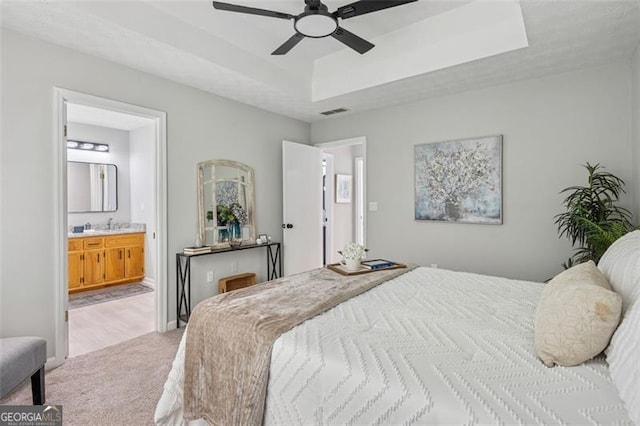 835 Navajo, Covington, GA 30016 - bedroom featuring light colored carpet, a raised ceiling, connected bathroom, and ceiling fan