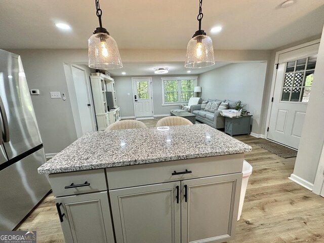 2165 S River Rd, Franklin, GA 30217 - kitchen featuring freestanding refrigerator, light wood-style floors, baseboards, a kitchen island, and decorative light fixtures