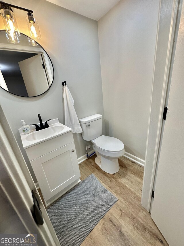 2165 S River Rd, Franklin, GA 30217 - half bathroom with wood finished floors, toilet, vanity, and baseboards