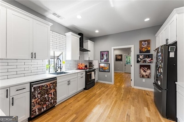 611 Pickett St SE, Atlanta, GA 30316 - kitchen featuring black appliances, wall chimney exhaust hood, backsplash, white cabinetry, and healthy amount of natural light