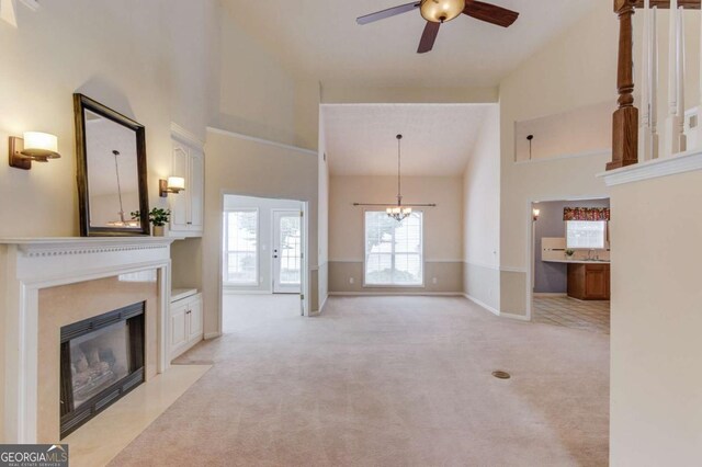 3585 Berkeley Park Ct, Duluth, GA 30096 - unfurnished living room with high vaulted ceiling, ceiling fan, a fireplace with flush hearth, light colored carpet, and baseboards